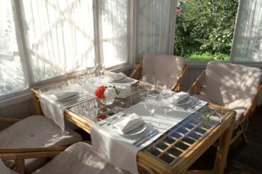 dining table near opened window empty glasses and plates