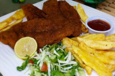 spicy fish fried with crispy potatoes by fatima's dining table.