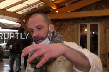 Restaurateur leads supporters in march against COVID measures after backing down on reopening