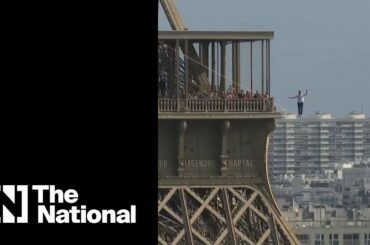 French daredevil walks a 70-metre high slackline from the Eiffel Tower