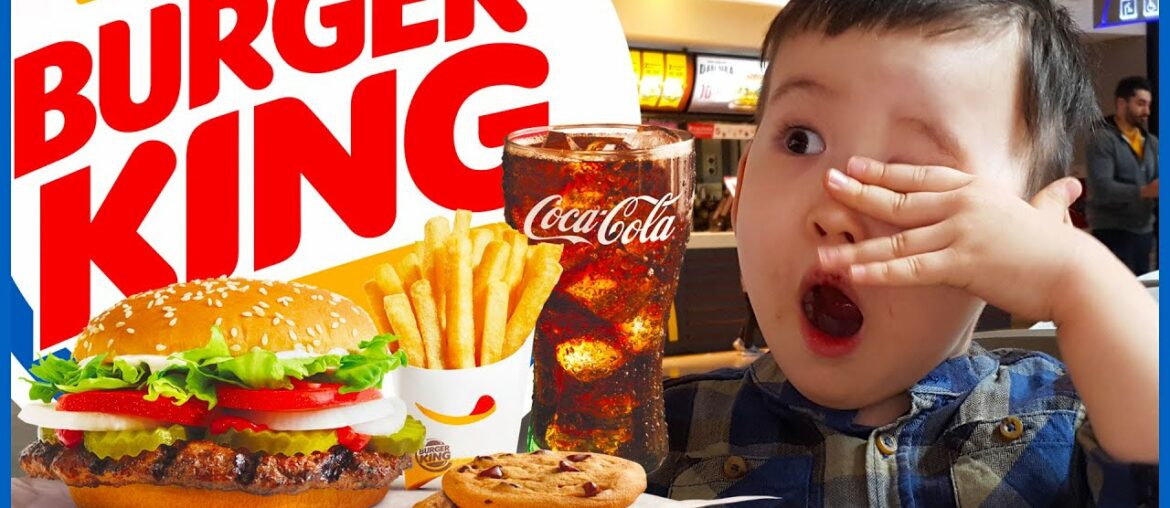 Childs hand shows thumbs up to homemade hamburger. Child eating fries and burger in restaurant. Childs hand shows thumbs up to homemade hamburger. Child eating fries and burger in restaurant.