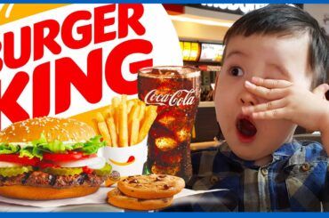 Childs hand shows thumbs up to homemade hamburger. Child eating fries and burger in restaurant.