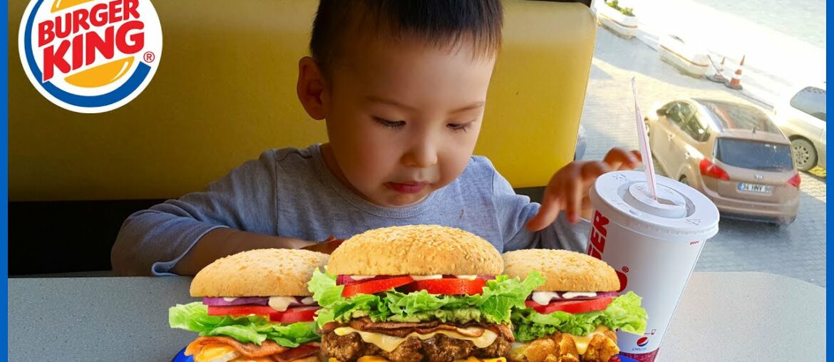 Asian boy is drinking and have full set meal of hamburger ,french fried and chicken in Burger King.