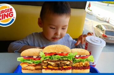 Asian boy is drinking and have full set meal of hamburger ,french fried and chicken in Burger King.
