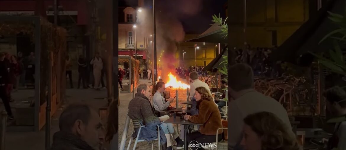 French diners enjoy wine as fire lit by protesters burns nearby | ABC News