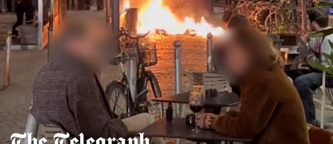 France protests: Couple enjoy glass of wine metres from raging street fire in Bordeaux