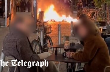 France protests: Couple enjoy glass of wine metres from raging street fire in Bordeaux