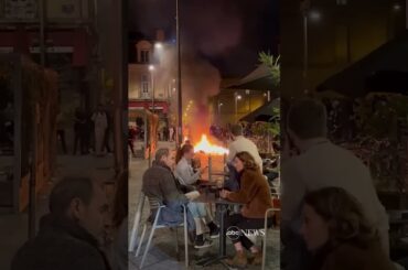 french diners enjoy wine as fire lit by protesters burns nearby abc news #shorts