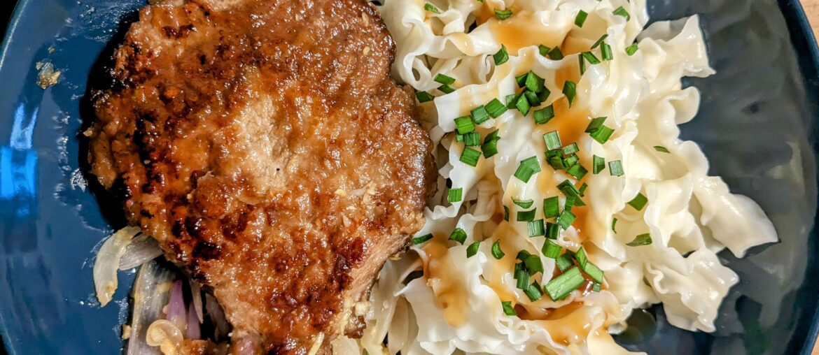 Côtelettes de porc marinées grillées à la poêle, nouilles aux oignons