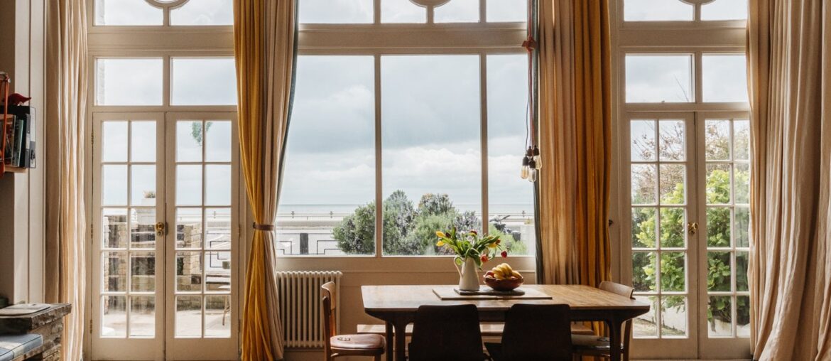 Living room opening up to a balcony overlooking the English Channel in a four-bedroom Victorian house built into the white cliffs of Ramsgate, Kent, England [1500x1000]