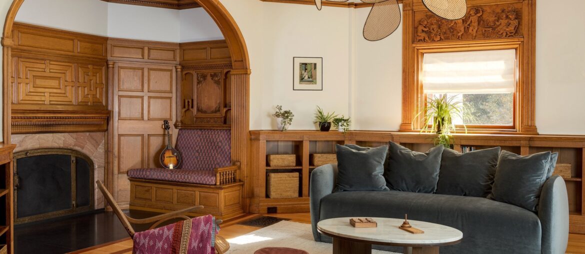 Fireplace nook in the living room of a renovated 1884 Queen Anne Victorian house with restored and cleaned original woodwork in the Boston suburbs, Massachusetts [2500x1667]