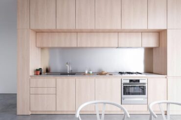 plywood cabinetry with stainless steel backsplash