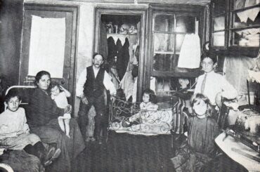 Italian immigrant family in combination kitchen/living quarters NYC, 1900.