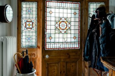 Front door with original stained glass paneling in the entry of a five-bedroom Victorian house, seaside town of Ilfracombe, North Devon coast, England [1067x1600]