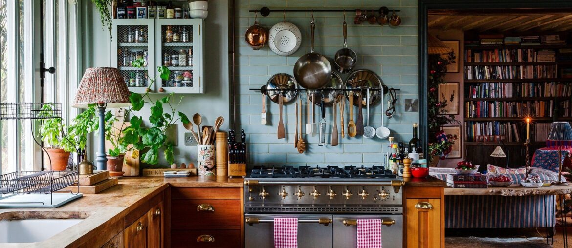 Bookshelf-lined living room seen from a country kitchen in a Cotswolds home, Stow-on-the-Wold, Gloucestershire, England [1920x2688]