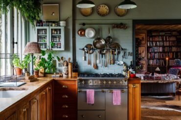 Bookshelf-lined living room seen from a country kitchen in a Cotswolds home, Stow-on-the-Wold, Gloucestershire, England [1920x2688]