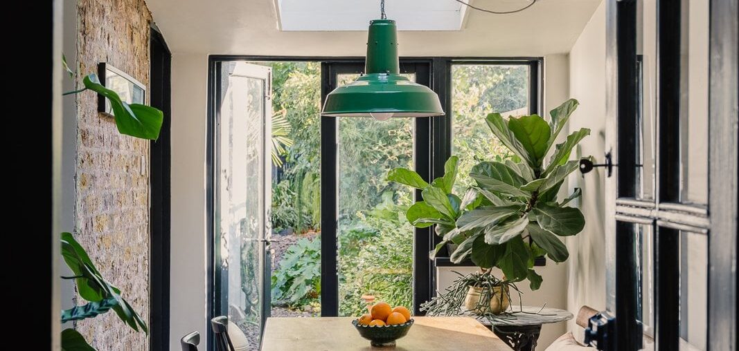 Dining room with skylights opening up to a tropical garden in a renovated Victorian house, Brixton, Lambeth, south London, UK [1067x1600]