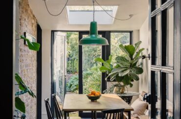 Dining room with skylights opening up to a tropical garden in a renovated Victorian house, Brixton, Lambeth, south London, UK [1067x1600]