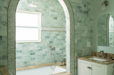 Arched shower alcove in a marble tile-clad bathroom, Los Angeles [1706x2560]