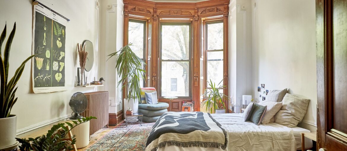 Bedroom with a bay window in an old Brooklyn brownstone apartment full of ornately carved wooden details, New York City [3000x2000]