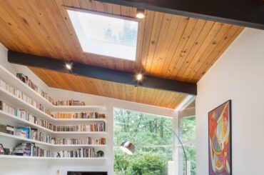 Tall living space lined with bookshelves under a skylight in a renovated Mid-century modern residence, Portland, Oregon [3840x5760]