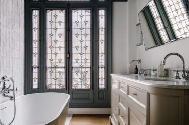 Bathroom with a stained glass window in an ornate 1920s apartment in the 17th arrondissement of Paris, France [1080x1350]