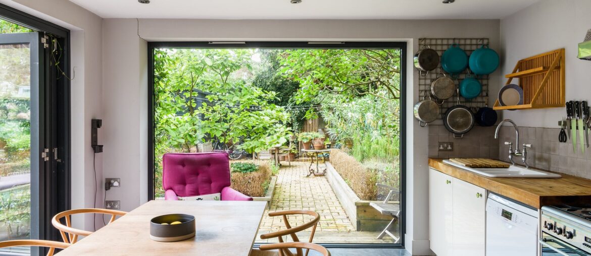 Garden views framed with a large window in the kitchen of a two-bedroom garden flat near Finsbury Park, North London, UK [2400x1600]