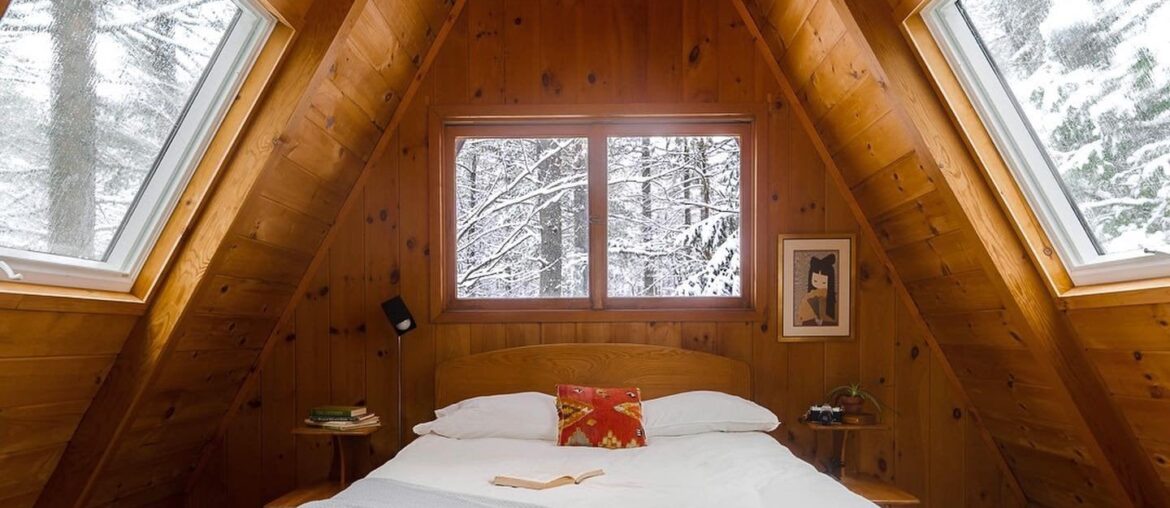 Attic bedroom in an A-frame cabin surrounded with winter forest views, Adirondack Park near Lake Placid in the Adirondack Mountains, Upstate New York [1440x1800]