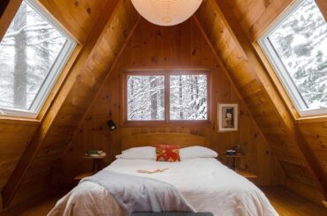 Attic bedroom in an A-frame cabin surrounded with winter forest views, Adirondack Park near Lake Placid in the Adirondack Mountains, Upstate New York [1440x1800]