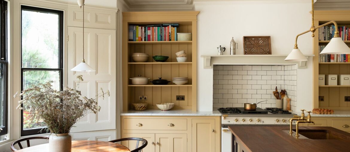 Below ground level kitchen with subdued yellow cupboards in an 1870s Victorian terrace house, Stoke Newington, Hackney, London, UK [2500x1663]