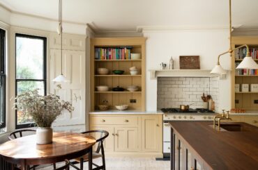 Below ground level kitchen with subdued yellow cupboards in an 1870s Victorian terrace house, Stoke Newington, Hackney, London, UK [2500x1663]