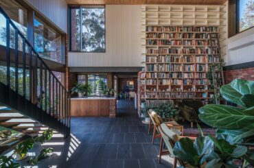 Double-height open living room with a tall bookshelf wall in a renovated 1980s residence, Ocean Grove, Victoria, Australia [2500x1667]