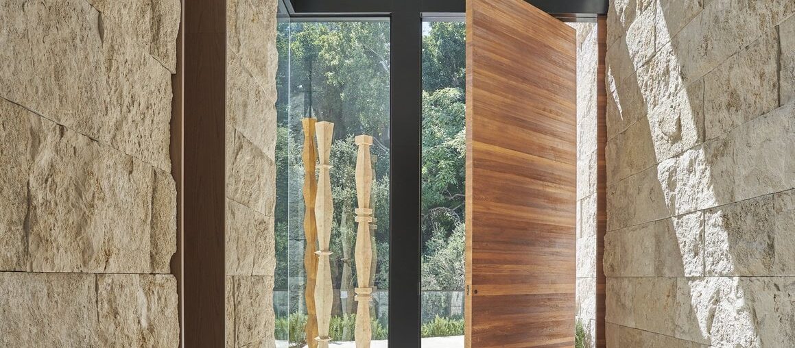 Massive wooden front hallway door in sunlit Sarbonne Road by Martha Mulholland Interior Design [1159x1200]