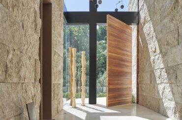 Massive wooden front hallway door in sunlit Sarbonne Road by Martha Mulholland Interior Design [1159x1200]