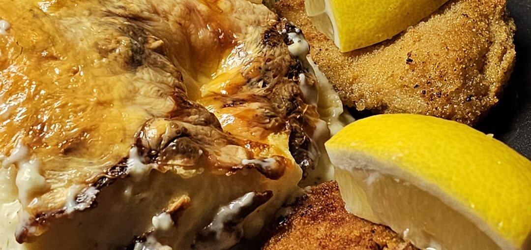 Homemade breaded schnitzel, with steamed cauliflower au gratin with béchamel