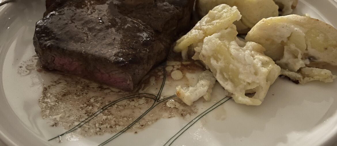 Strip steak, pommes au gratin and black garlic butter.