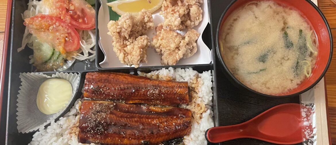 Grilled eel bento with fried chicken, miso soup, and salad in Berlin