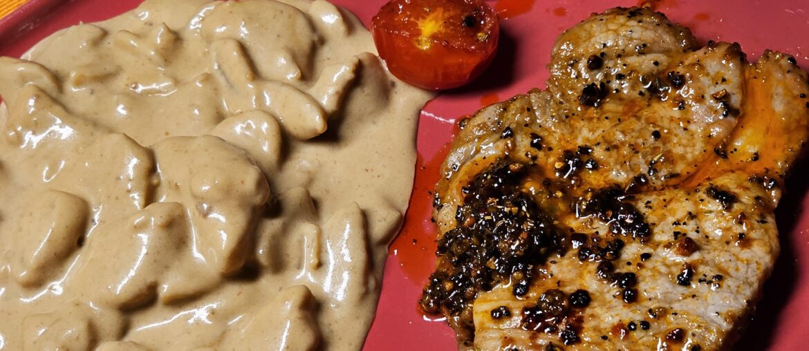 Steak with potato salad, grilled halved cocktail tomatoes, and homemade herb butter