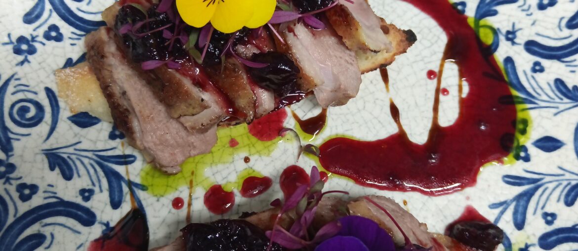 Bruschetta de magret de canard sous vide, sauce de cerises épicée.