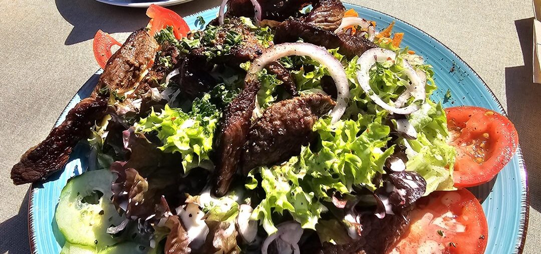Argentinean beef strips, herb butter, mixed leaf salad with tomatoes, cucumbers, peppers, carrots, onions, pumpkin seeds and baguette; Lake Constance (Germany)