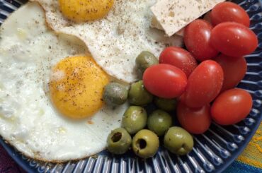 Fried eggs with olives, tomatoes and feta.
