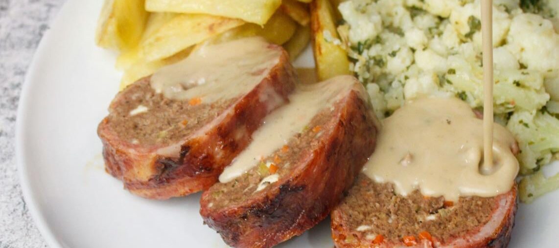 Meatloaf with feta cheese & vegetables wrapped in bacon, served with roast potatoes, cauliflower tossed in herbs and a pepper sauce