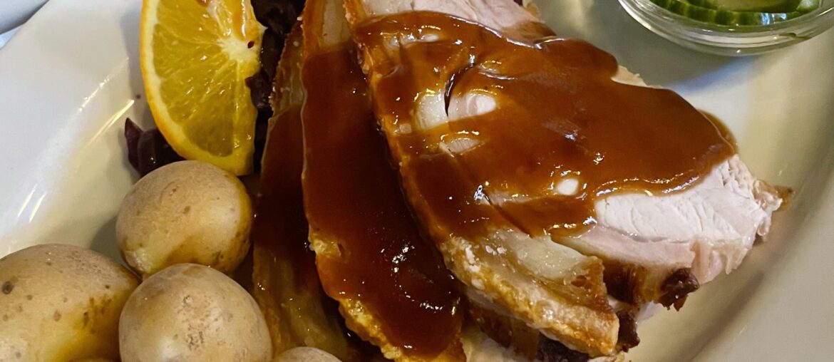 Danish style roast pork with boiled potatoes, red cabbage, and cucumber salad in Copenhagen