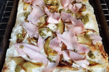 Pinsa Romana. Base crème ricotta pecorino. Aubergine grillées, pesto citron, pointe de poudre d'amande, prosciutto cotto aux herbes.