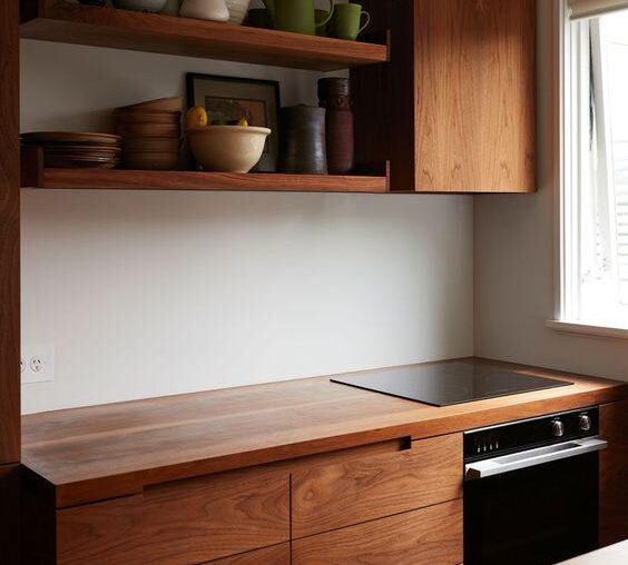 A small apartment kitchen with rich walnut cabinetry [564x734]
