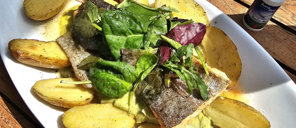 Fried salmon trout fillet on broccoli and lime cream with rosemary butter and swivel potatoes; served in Allensbach, Lake Constance, Germany