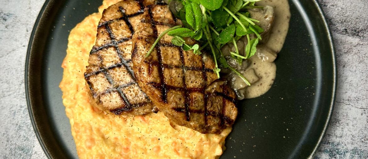 Grilled pork chops on mashed potatoes & carrots served with mushrooms stewed in a cream sauce with horseradish