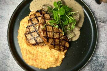 Grilled pork chops on mashed potatoes & carrots served with mushrooms stewed in a cream sauce with horseradish