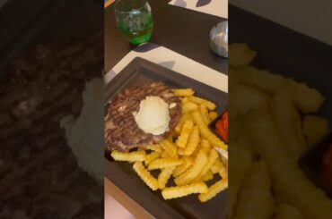 A gourmet flapper filled with cheese and pieces of bacon with french fries.