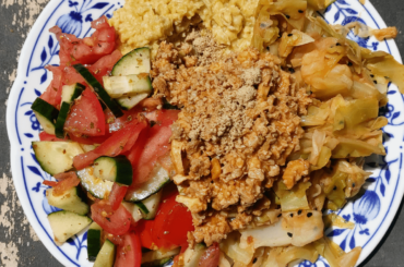 Savory porridge, vegan protein sauce, tomato and cucumber salad, cabbage.